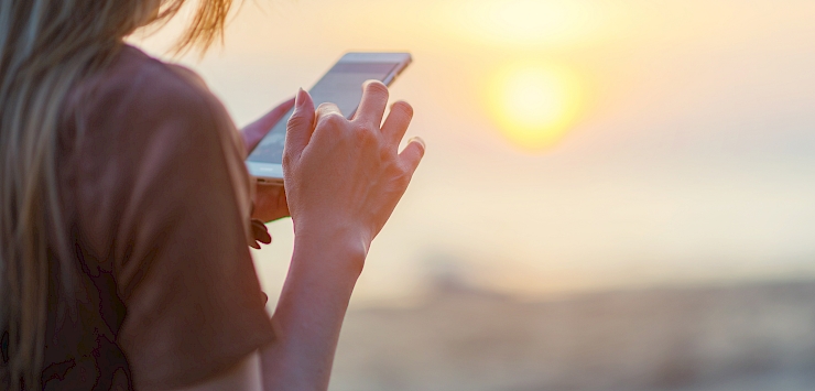 Women using an app on a beach on holiday