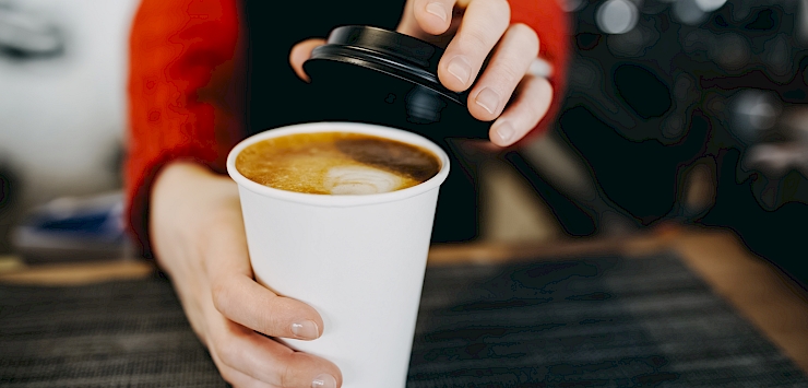 Barista handing over coffee cup